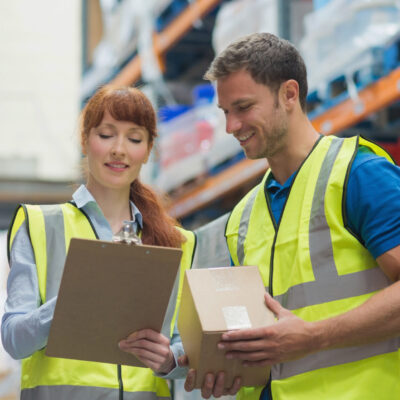 Smiling warehouse manager and delivery man in warehouse