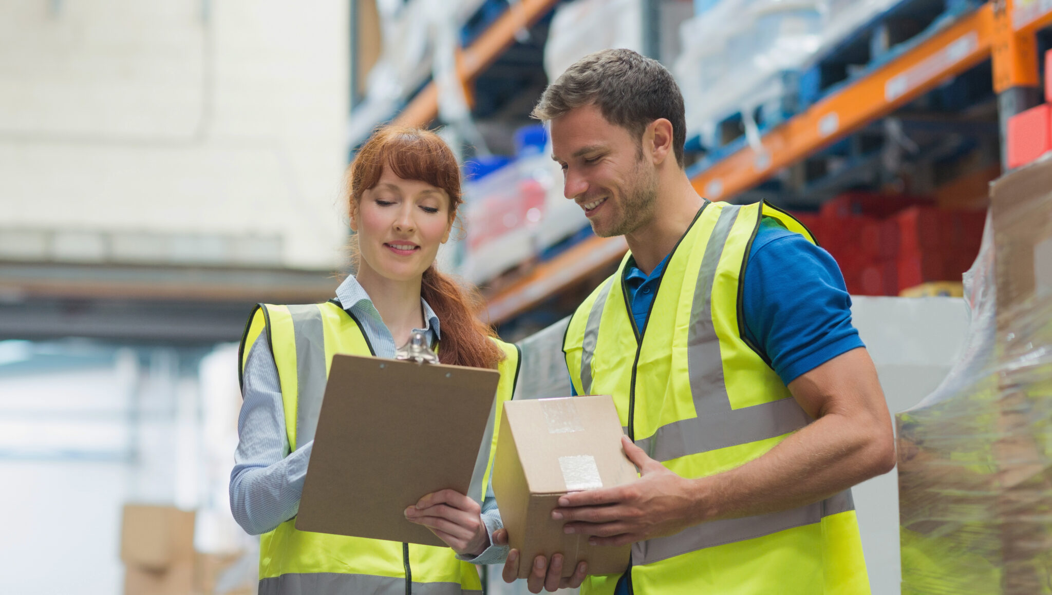 Smiling warehouse manager and delivery man in warehouse